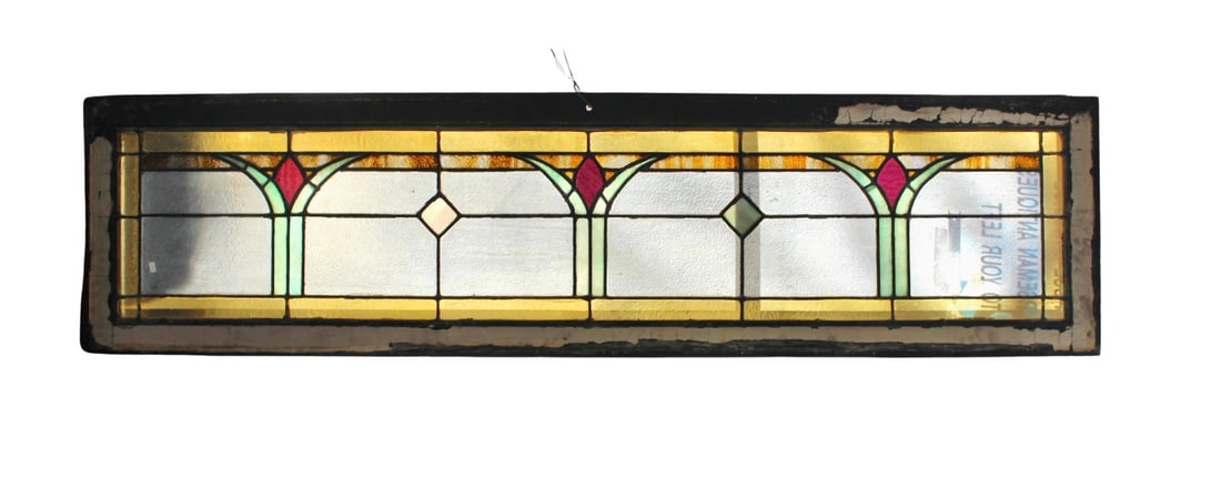 Early 20th Century Transom Window 63" x 16": Long transom window with Art Deco style designs in colored glass. Split into three sections with three roses in each pane. Currently housed in a wooden frame - the overall dimensions are for the