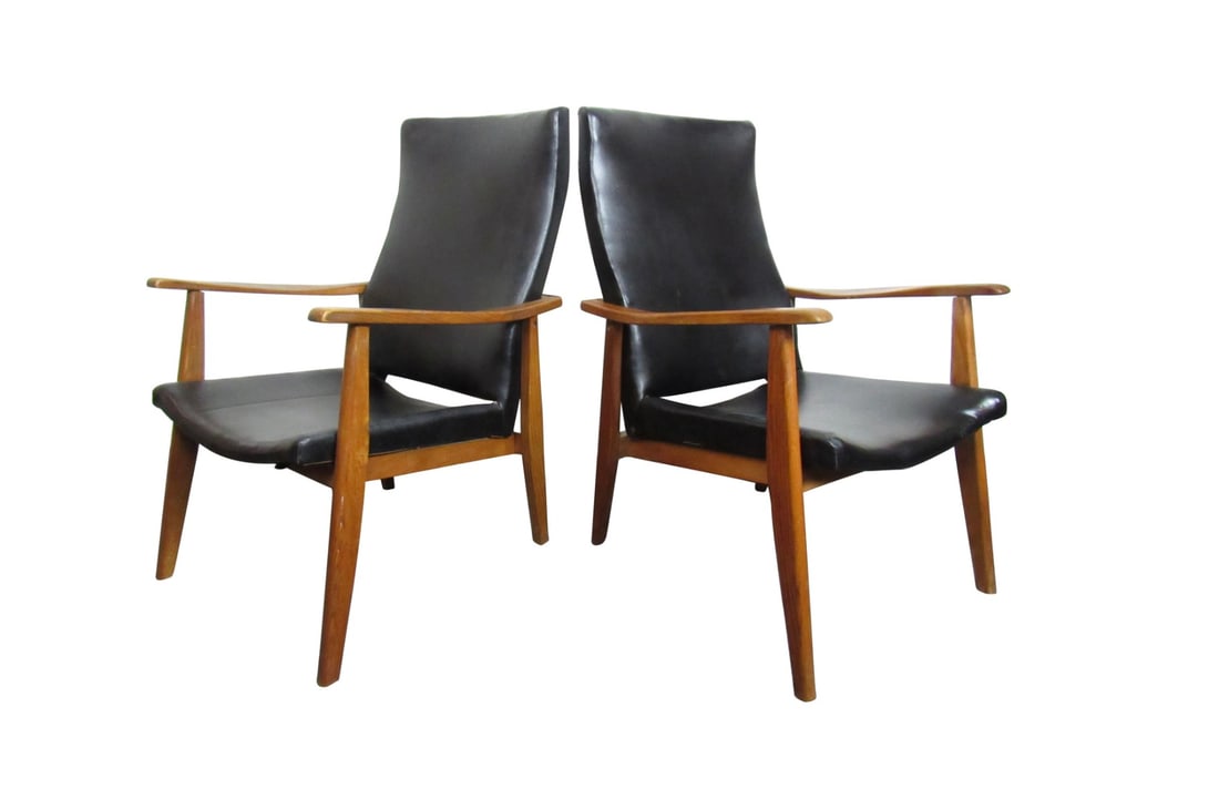 Pair of Mid-Century Modern Vinyl Lounge Chairs: This vintage pair of Mid-Century Modern lounge chairs combines black vinyl with a rich wooden frame for a stylish and comfortable design. // PICKUP LOCATION: BROOKLYN, NY // Condition: Good.