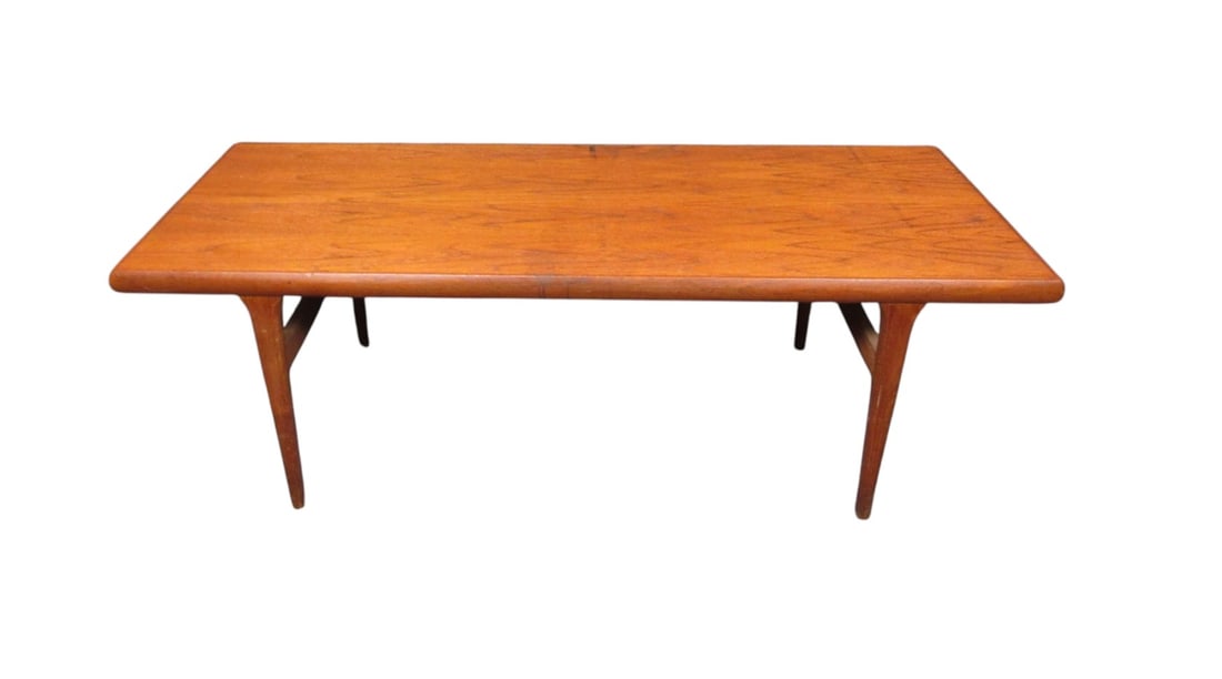 Danish Mid-Century Coffee Table, Teak Wood, 1960s: A classic mid-century Danish coffee table with a beautiful natural teak grain. Slender, carved legs give a sleek profile, sure to work well with a variety of styles. An ample tabletop makes this piece