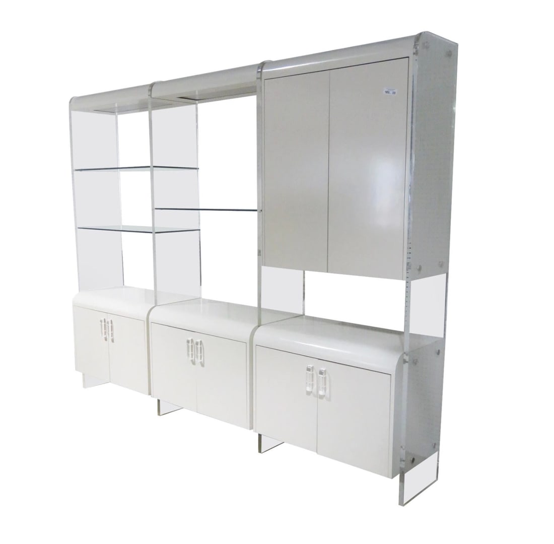 Mid-Century Modern Lucite and Formica Wall Unit, circa 1980s: Large modular Mid-Century Modern wall unit offering multiple flexible storage options. Impressive 1" thick Lucite columns support cabinets, shelves and overhead light canopies. Double door lower