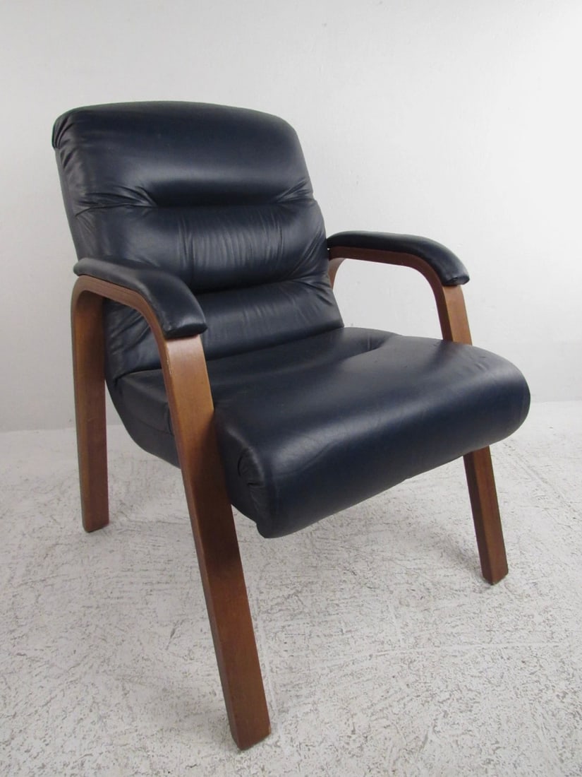 Mid-Century Modern Dark Blue Vinyl Lounge Chair: This stunning mid-century modern vinyl lounge chair features a deep blue color and upholstered arm rests for added comfort. The stylish blonde wood compliments the dark blue vinyl making it the