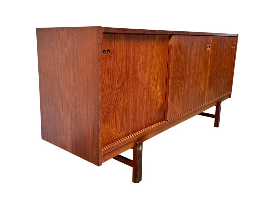 Danish Modern Teak Credenza by Ib Kofod-Larsen, 1960s Design: Embodying the essence of mid-century Scandinavian elegance, this Danish Modern Teak Credenza is a stunning example of minimalist form meeting functional beauty. Likely designed by renowned Danish