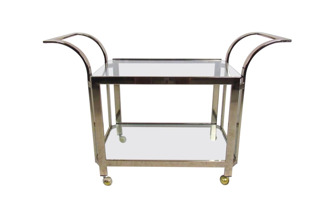 Stylish Mid Century Modern Brass Serving Cart: This vintage modern serving cart features two-tiered glass shelves for bottle or glassware storage. An ideal shop display or bar service cart, the shapely modern design and vintage brass finish add