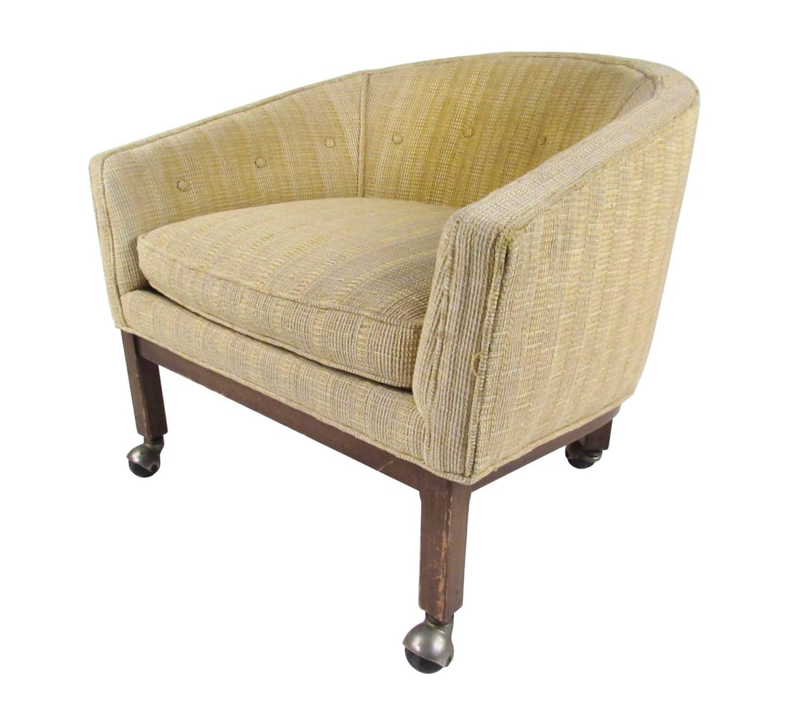 Midcentury Barrel Back Club Chair: This Mid-Century Modern club chair features vintage upholstery, sturdy walnut legs, and casters for ease of movement. The comfortable proportions of this barrel back rolling lounge chair make it the