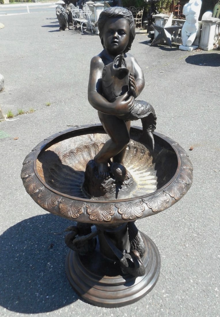 Bronze Fountain with Boy Holding Fish: Gorgeous bronze fountain with one spacious reservoir. Intricately detailed representations of water fowl on the base along with a boy holding a fish on the top. Quality construction and material