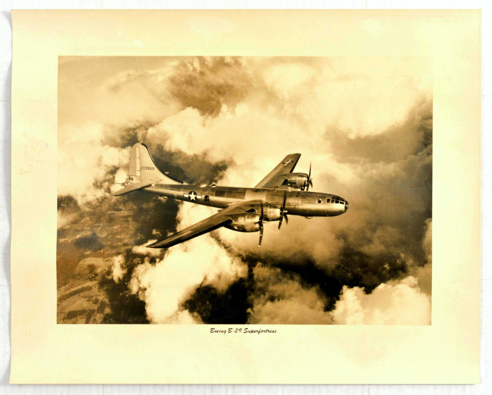Advertising Poster Boeing B-29 Superfortress: Original vintage war advertising poster for the Boeing B-29 Superfortress aeroplane flying above the clouds. Sepia toned photograph of the plane which is a four engined propeller-driven heavy bomber d