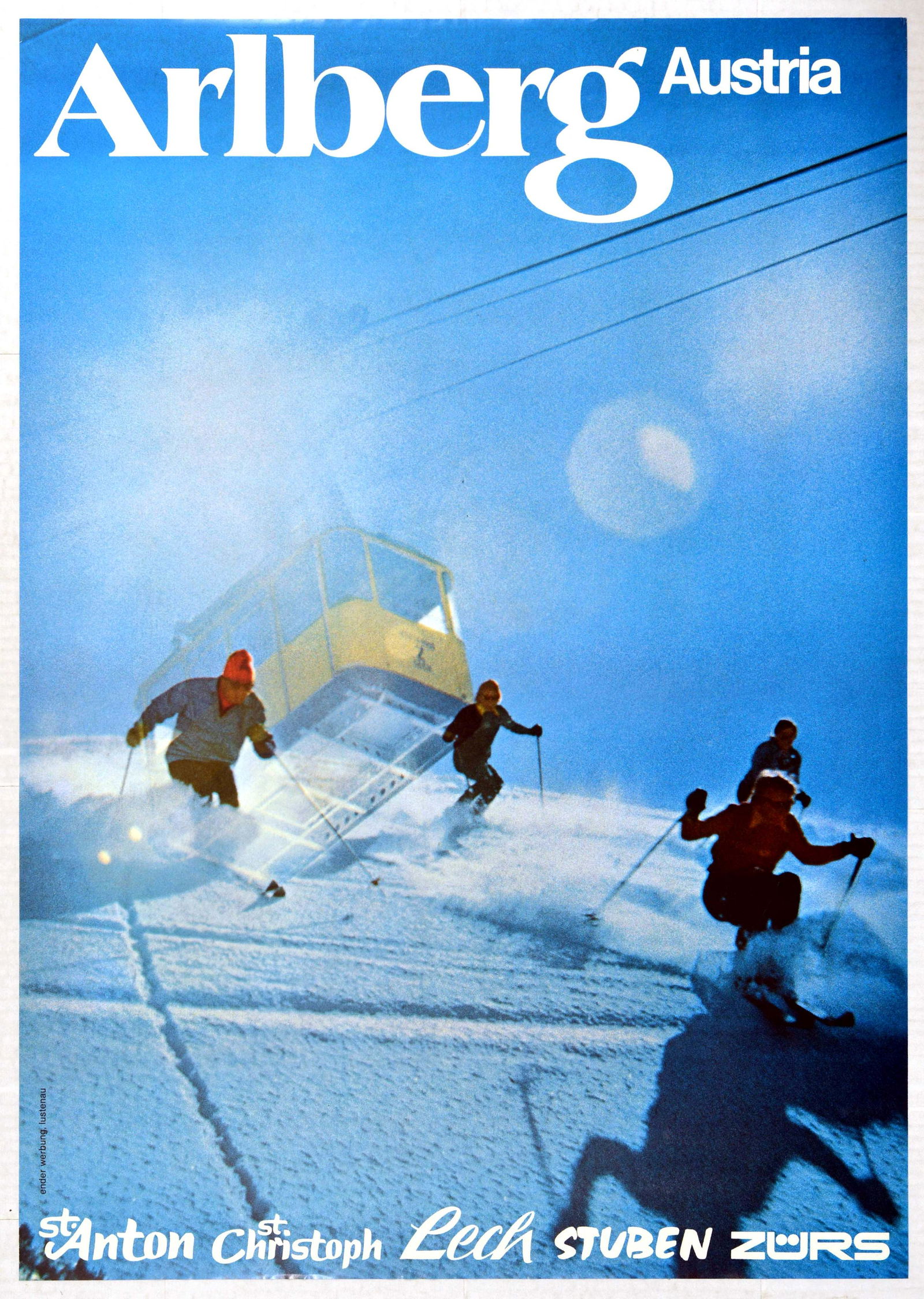 Sport Poster Ski Arlberg Austria Lech Stuben Zurs St: Original vintage ski travel poster for Arlberg in Austria featuring skiers skiing down a snowy mountain slope with sun shining from behind a cable car in the background. Stylised white lettering highl