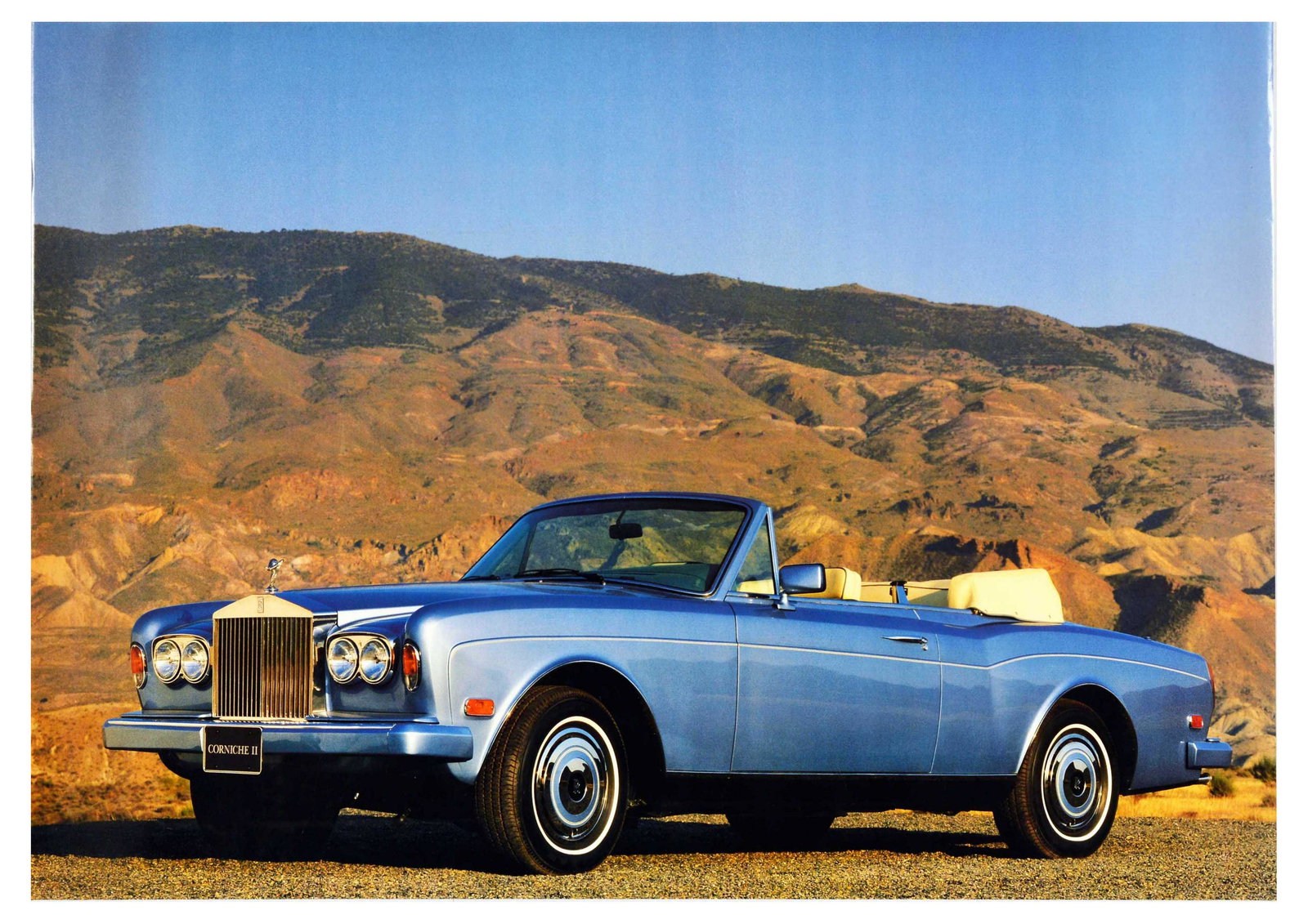 Advertising Poster Corniche II Rolls Royce Mountain: Original vintage advertising poster for Rolls-Royce Corniche in blue on a mountain road. Corniche II is a two-door convertible car produced from 1986 to 1989. Rolls-Royce was a British manufacturer of