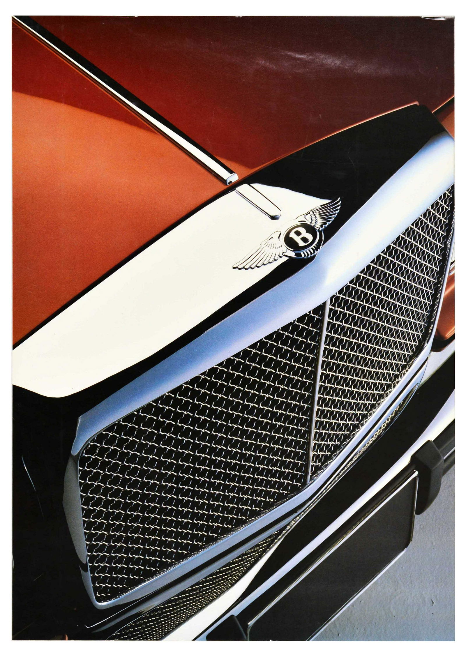 Advertising Poster Bentley Grill Red Luxury Automobile: Original vintage advertising poster for Bentley featuring a photograph of the front silver grill of the red car with soaring wings Bentley logo on the front. Bentley is a British manufacturer of luxur