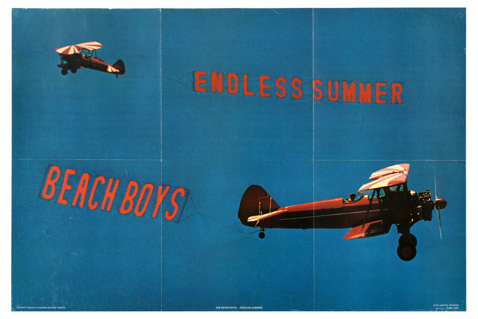 Advertising Poster Beach Boys Endless Summer Boeing Stearman Biplane: Original vintage music advertising poster for Beach Boys Endless Summer compilation album featuring two Boeing Stearman biplanes (1933-45) flying in the blue sky towing the advertising banners. Horizo