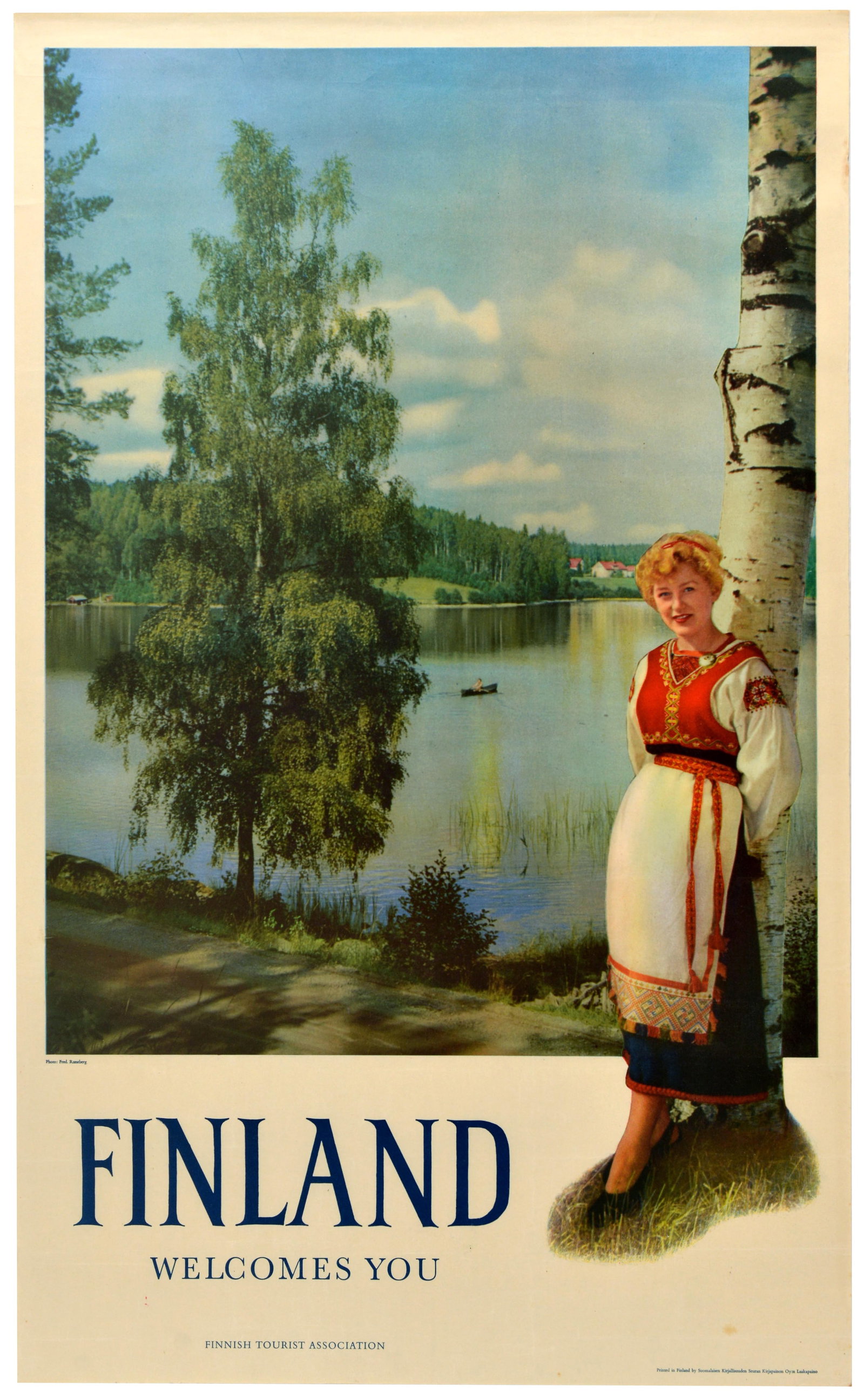 Travel Poster Finland Welcomes You Lake Birch Traditional Costume: Original vintage Nordic travel advertising poster - Finland Welcomes You - featuring a young smiling lady dressed in a traditional folk costume, a red embroidered bodice, an apron, and a dark skirt, s