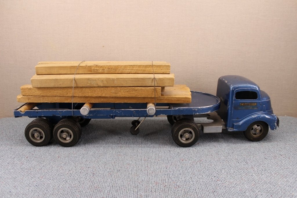 Smith Miller Steel Flat Bed Lumber Truck: Truck and trailer. Decals on each door read ' Smith -Miller Smitty Toys California Famous Trucks in Miniature'. Total length is 23 inches. Very good condition. Missing a metal roller, see photo.