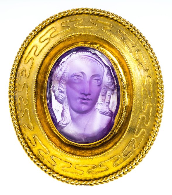 ANTIQUE CARVED AMETHYST CAMEO BROOCH: ANTIQUE CARVED AMETHYST CAMEO BROOCH the carved amethyst depicting the bust of a woman within a bead and ropework decorated frame, 5.2 x 4.7 cm, gross weight 15.1 grams