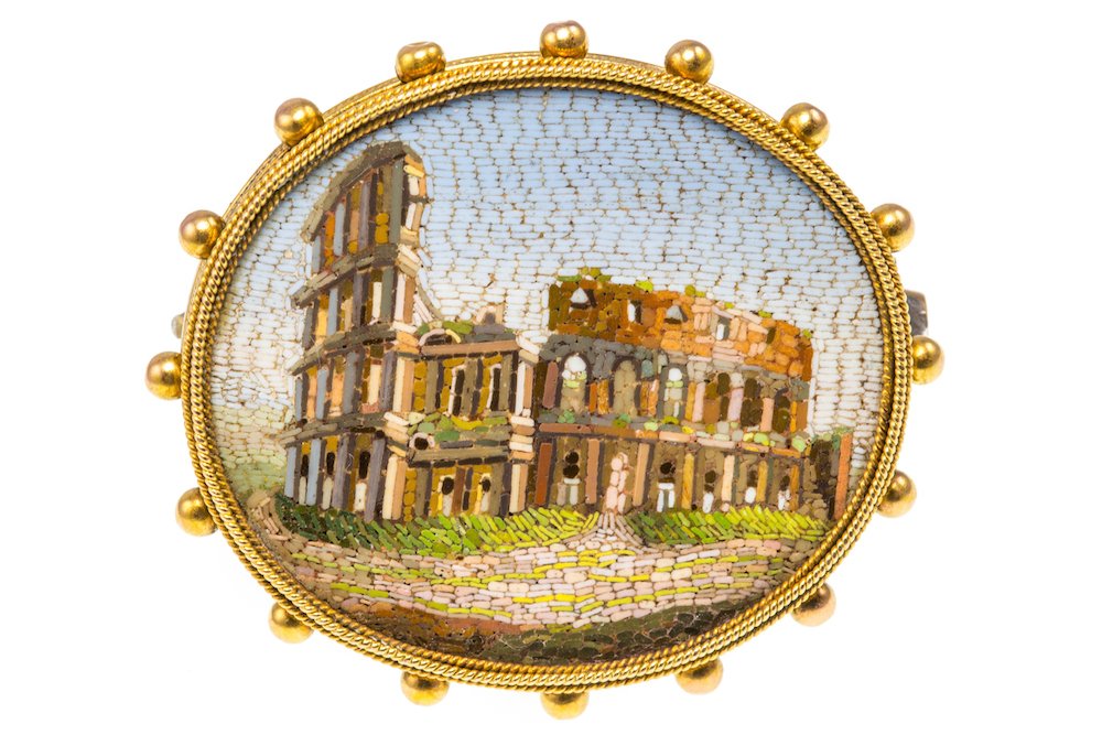ANTIQUE MICROMOSAIC BROOCH: ANTIQUE MICROMOSAIC BROOCH A Victorian micromosaic brooch, the oval micromosaic of the Roman coliseum set within a beaded closebacked frame, measuring approximately 3 x 2.6 cm, gross weight 7.8 grams