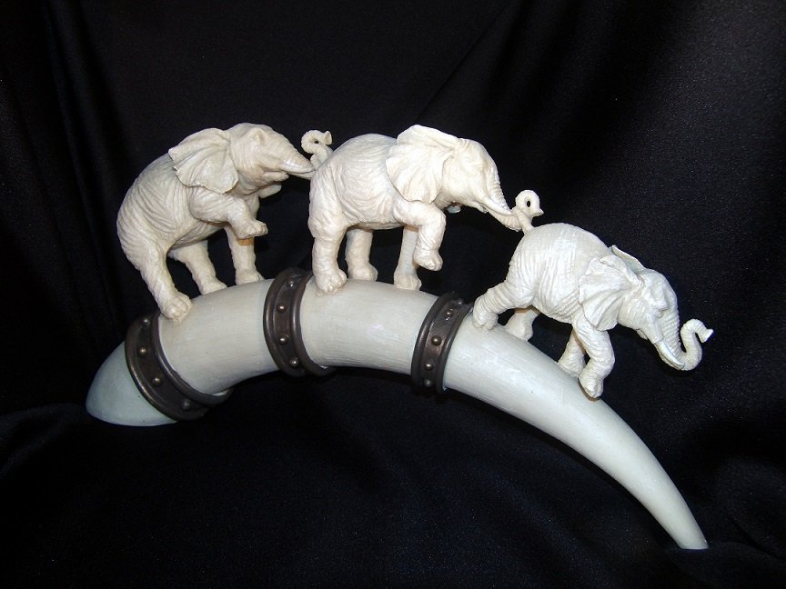 Elephants on Tusk Statue: They march together with trunks connected to the tail. These bone colored elephants and decorative bone colored arched base deserve a special place in your home. Remember, when the trunks are up - goo