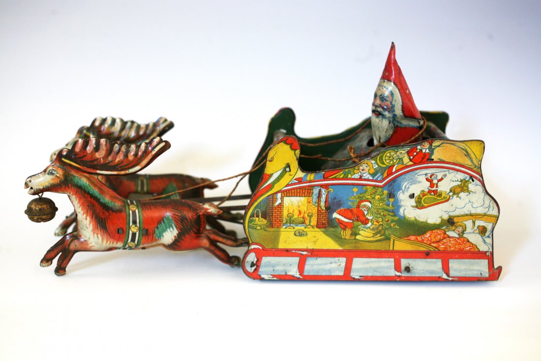 SANTEE CLAUS SLEIGH TOY: Ferdinand Strauss Corp., lithographed tin, depicts Santa riding open sleigh pulled by two reindeer,not working and miss Santa arm. 10 3/4" l.