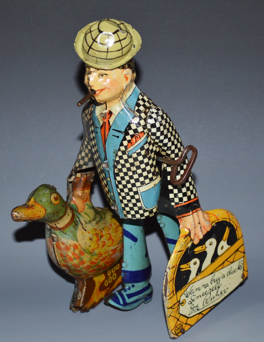 1930's Marx Joe Penner Buy a Duck Windup Walker: Description American. Working. Depicts Joe Penner with original hat smoking a cigar and walking his Duck, Goo Goo. Bright, shiny, and glossy litho. Minor scratching overall. Condition (Very Good - Exc