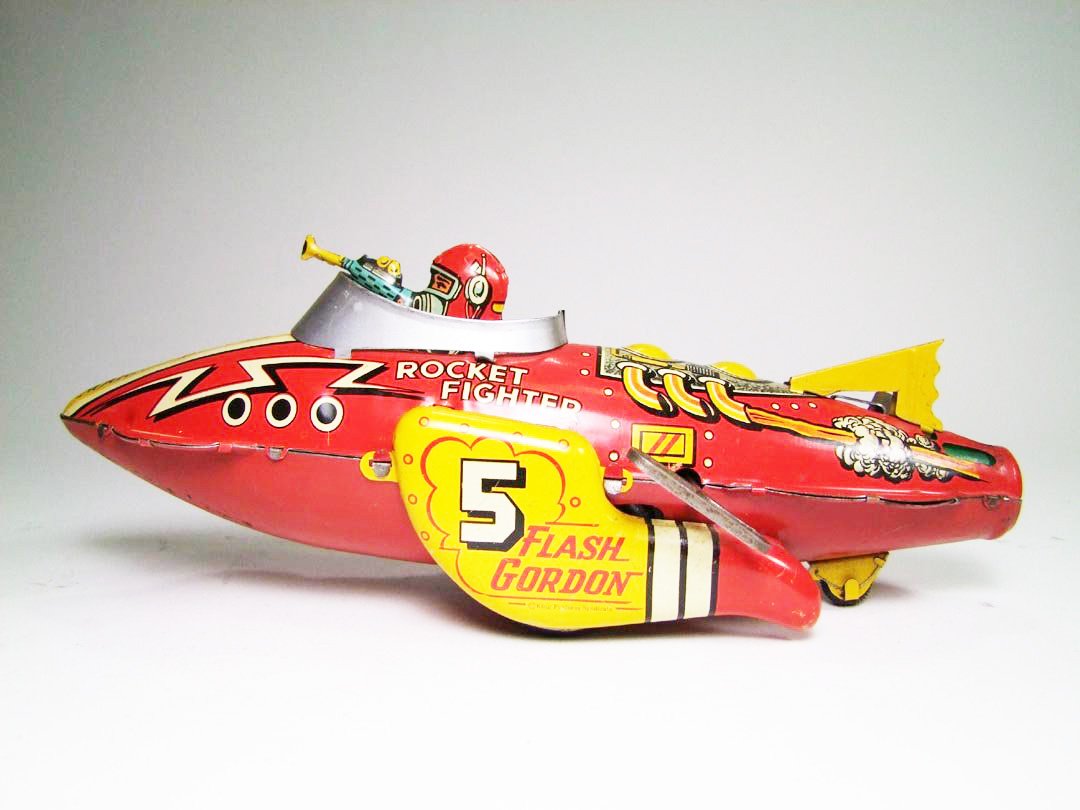Flash Gordon Rocket Ship: 1939 Marx wind-up Flash Gordon Rocket Fighter. Sparks shoot out of the back of the rocket ship as it scoots across the floor. 12" long.