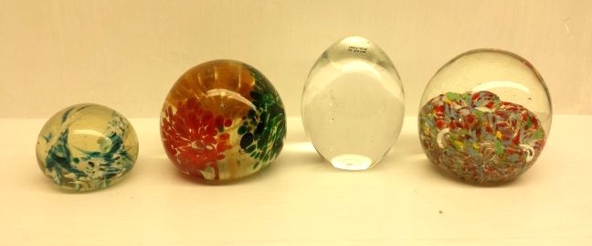 4 PAPERWEIGHTS: Lot of 4 paperweights. 1 is round w/ blue and white flower design. 1 is round with orange, green and red flower design. 1 is egg shaped clear no design. 1 round w/ tri-colored melting glass design wit