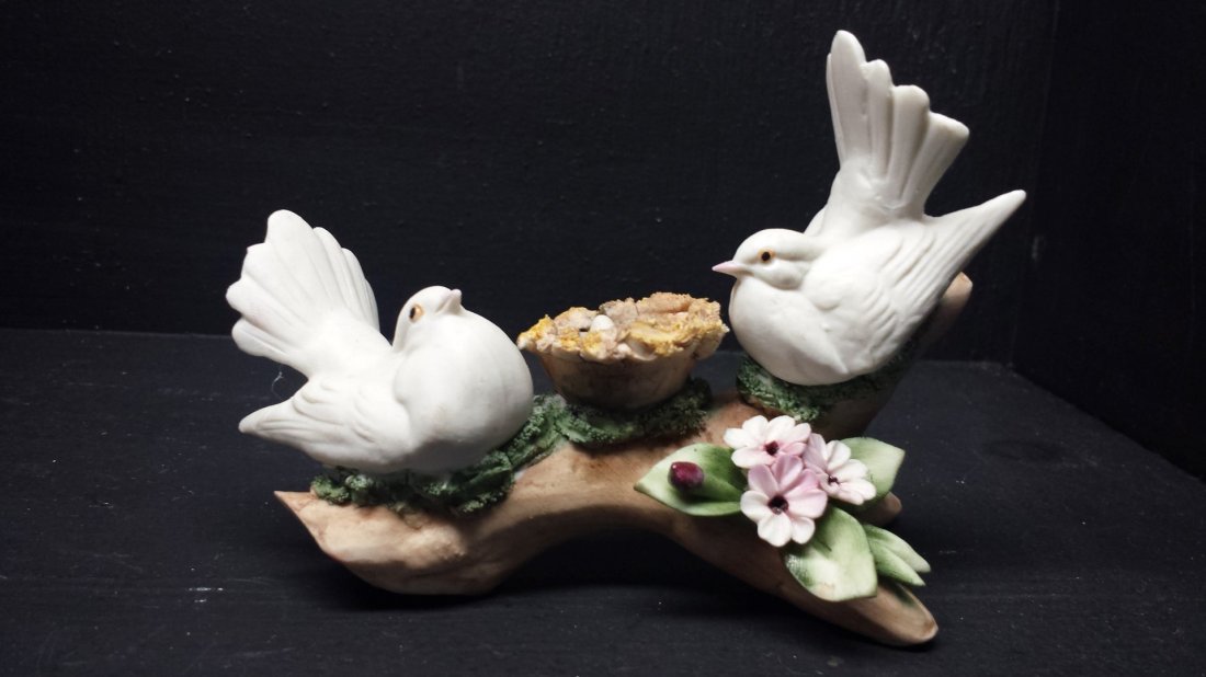 CAPODIMONTE PORCELAIN LOVE BIRD FIGURINE: This is a Capodimonte porcelain figurine that features 2 love birds with a basket of eggs. 5 1/4in.L. X 3 3/4in.T. TOTAL WEIGHT:112.0GRAMS
