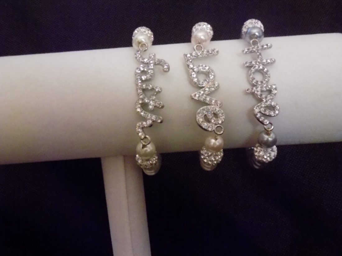 SET OF THREE COLOR BEADED STRETCH PLACES W/ CRYSTALS: This is a set of 3 Bracelets that are colored beads Pink, Blue, and White colored. each are stretch style. Each one has a different word in crystals. PINK:LOVE, WHITE: FAITH, BLUE: HOPE. They also fea