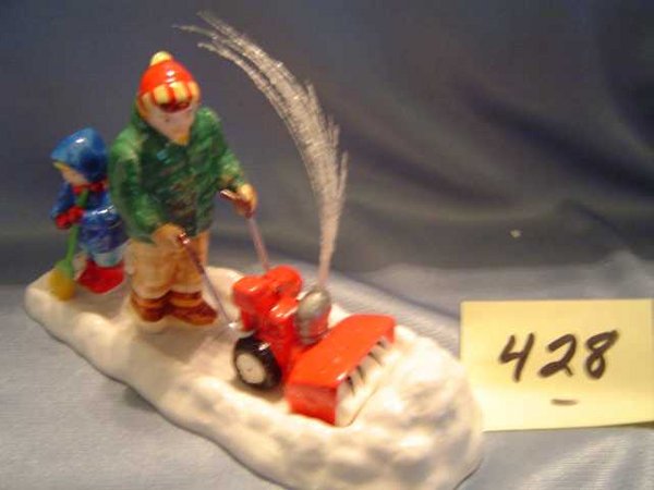 Dept 56 S.V. "Let it Snow, Let it Snow": Figure pushing a snow blower through a pile of snow while child follows behind and "snow" blows out top of blower. Comes in its own original box; mint condition. Green book # 5492-3. Retired in 2000.
