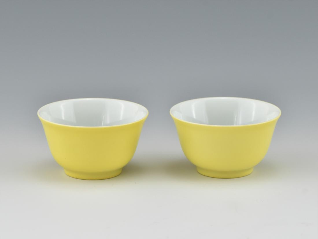 PAIR OF CHINESE LEMON YELLOW RICE BOWLS: Pair of Chinese porcelain wine cups, finely potted with simply bowl shape. The steep slightly curved sides everted from a round cavetto, raised on recessed foot base. The exterior covered evenly in a 