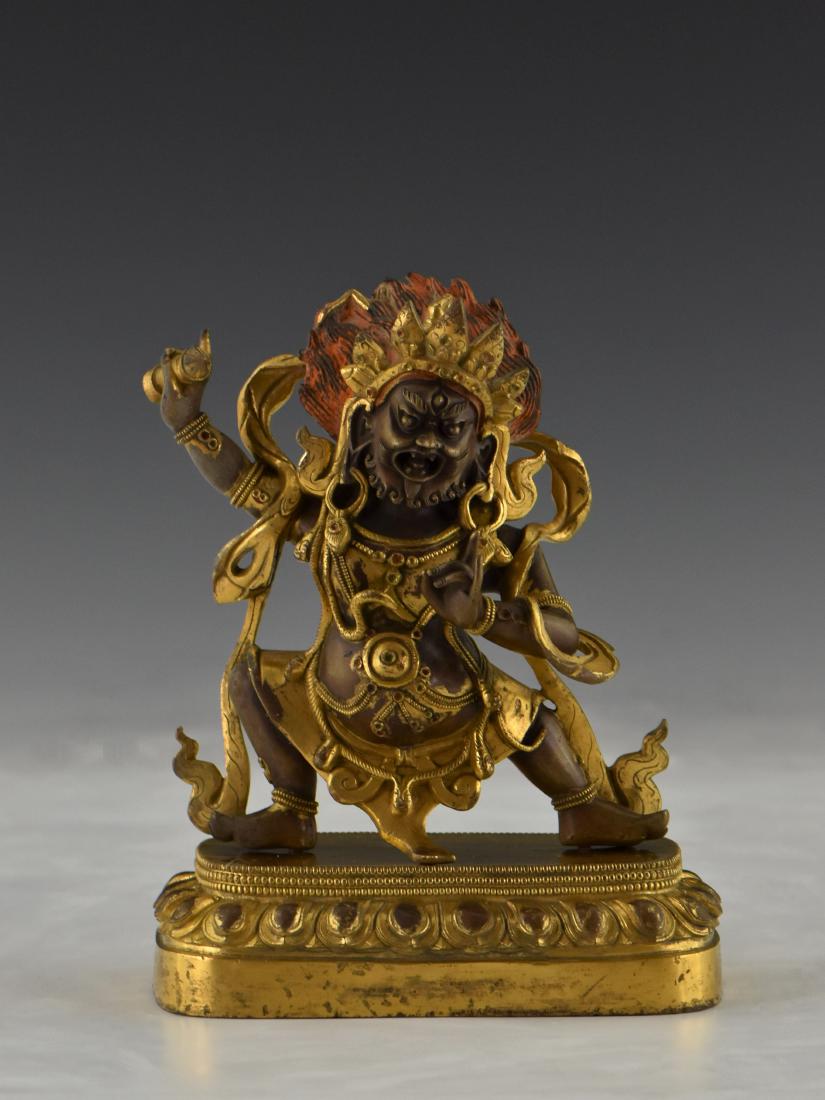 QING GILT BRONZE BUDDHA FIGURE OF VAJRAPANI: Qing Dynasty Chinese Sino-Tibetan gilt bronze Buddha figure of Vajrapani, dark blue in colour with one face and two hands, appears in the form of a raksha (a demon of classical Indian mythology) with 