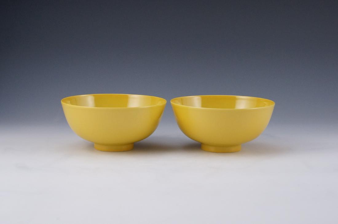 PAIR OF FAMILLE JAUNE CHINESE PORCELAINÂ BOWLS: Finely potted Chinese porcelain unto a simply rounded vessels, everted a steep sides toward the flat rim, raised upon a concave footed ring base. All reserve in pale-yellow glazed ground, while the co