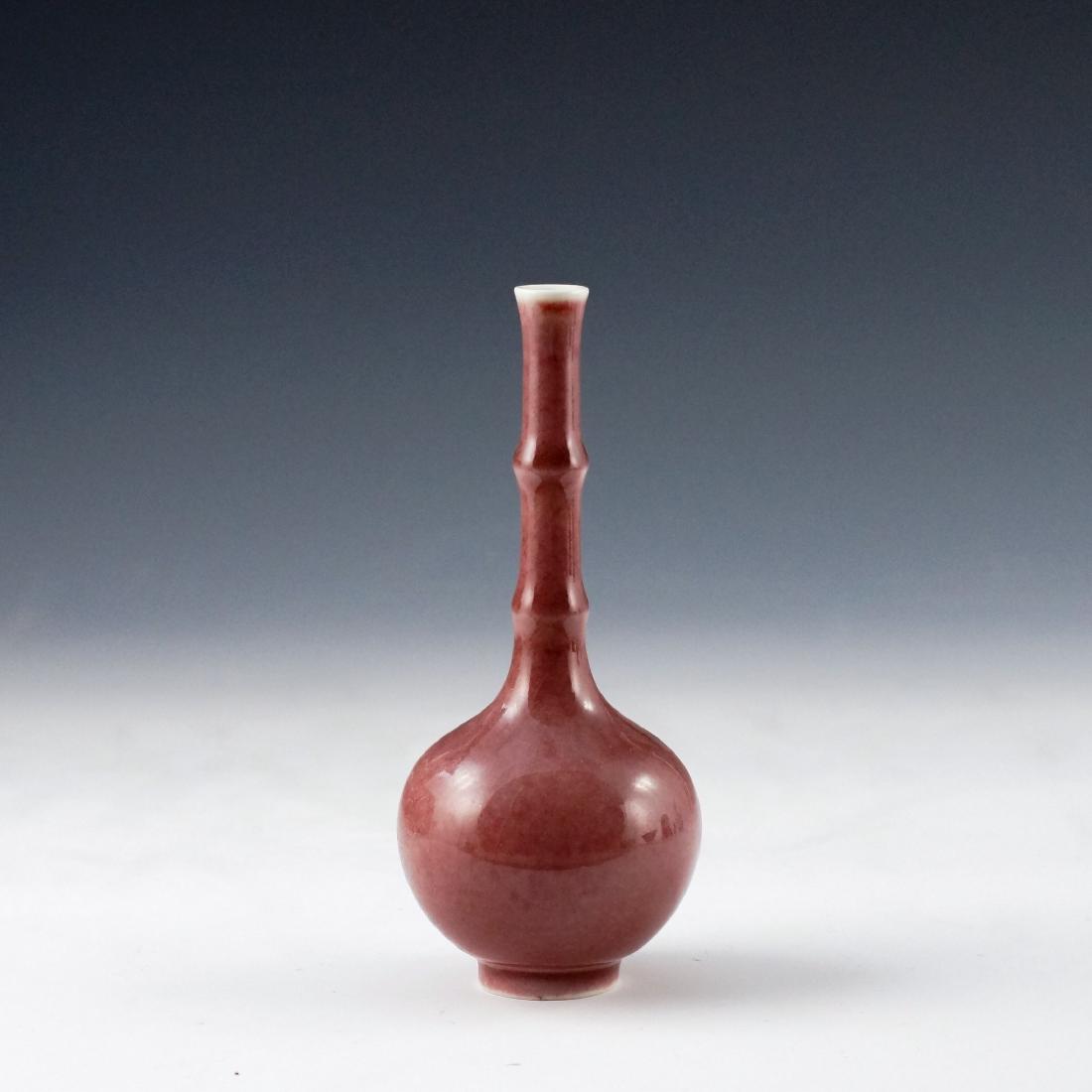 RED MONOCHROME PEKING BOTTLE VASE: Chinese porcelain Peking bottle vase is finely potted in bulbous body, tapered gracefully toward tall cylindrical straight neck supporting a slightly flaring rim, raised upon a footed base. Two ring r