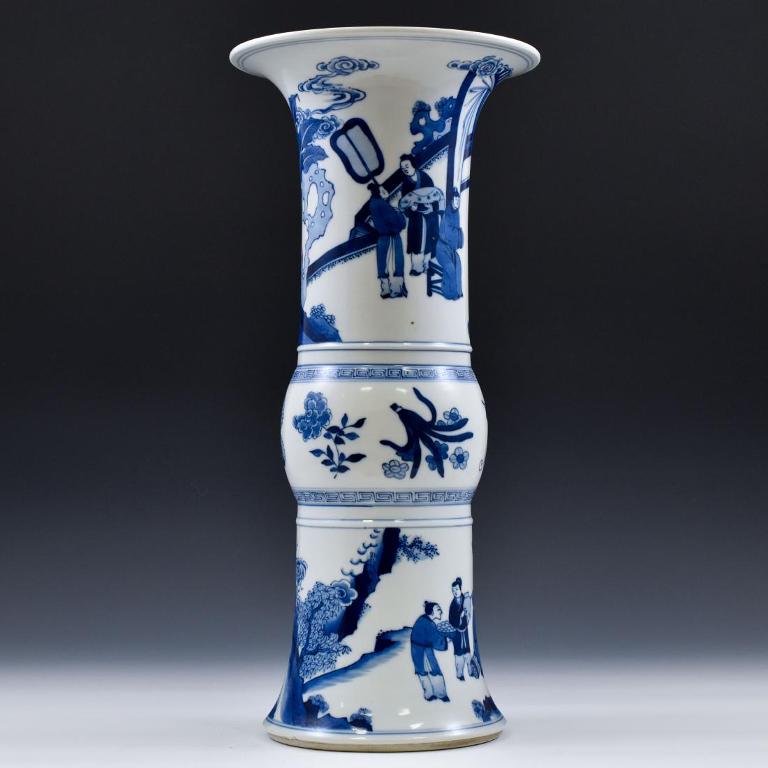 FINE CHINESE BLUE & WHITE PORCELAIN GU VASE: The vase potted in a Chinese porcelain traditional Gu shape. The beaker having baluster shaped body, with bulging belly, trumpet-shaped neck are painted in blue underglaze depicted officers and attend