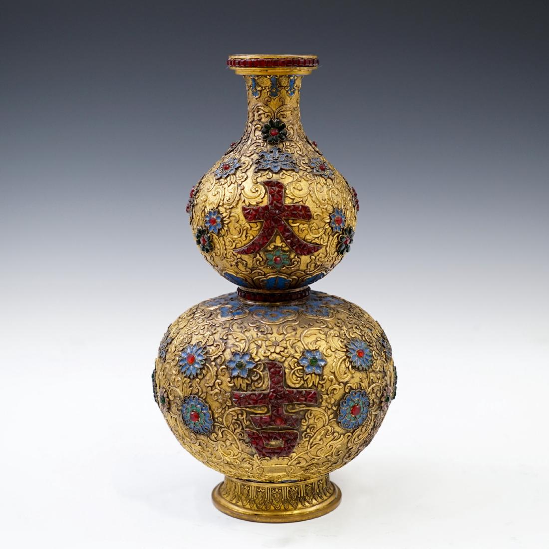GILT BRONZE ENAMEL INLAID DOUBLE GOURD VASE: Antique Chinese repoussed gilt bronze double gourd vase, the exterior elaborately decorated in relief with rococo floral motif, adorned with butterflies and floral pale-blue and green enamel medallion