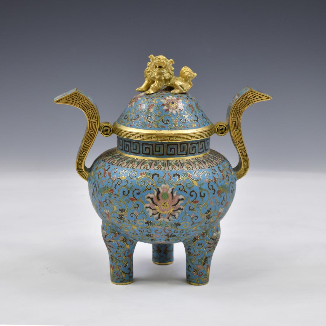 GILT BRONZE CLOISONNE TRIPOD CENSER: Bronze forged Tripod censer decorated in cloisonne chinoiserie. Large bulbous body with S-shaped handles, domed gilt lid, and ornate lion effigy finial. Tripod footings protrude from the bottom of the