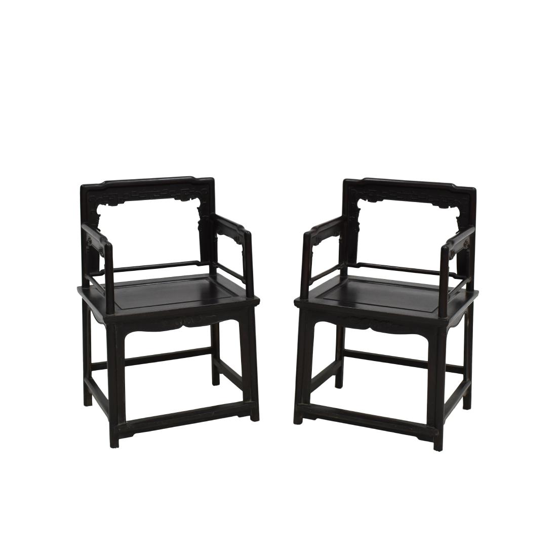 PAIR OF CARVED ZITAN ROSE ARM CHAIRS, MEIGUI YI: Each with an open-carved back frame formed by a straight top rail rounding the corners to the back posts, set with an inset beaded border apron and spandrels, the straight arms continuing down to form