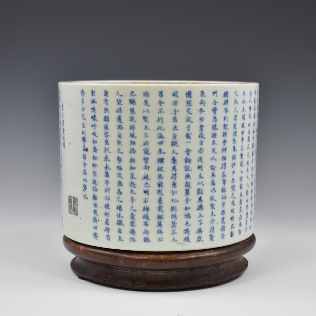 BLUE & WHITE CALLIGRAPHY PORCELAIN BRUSH POT ON STAND: Chinese Blue and White Porcelain Brush Pot. Bucket-shaped beaker with straight rim, over all covered with a brilliant smooth and shiny white glaze. The exterior has a intriquely of handwriting inscrip