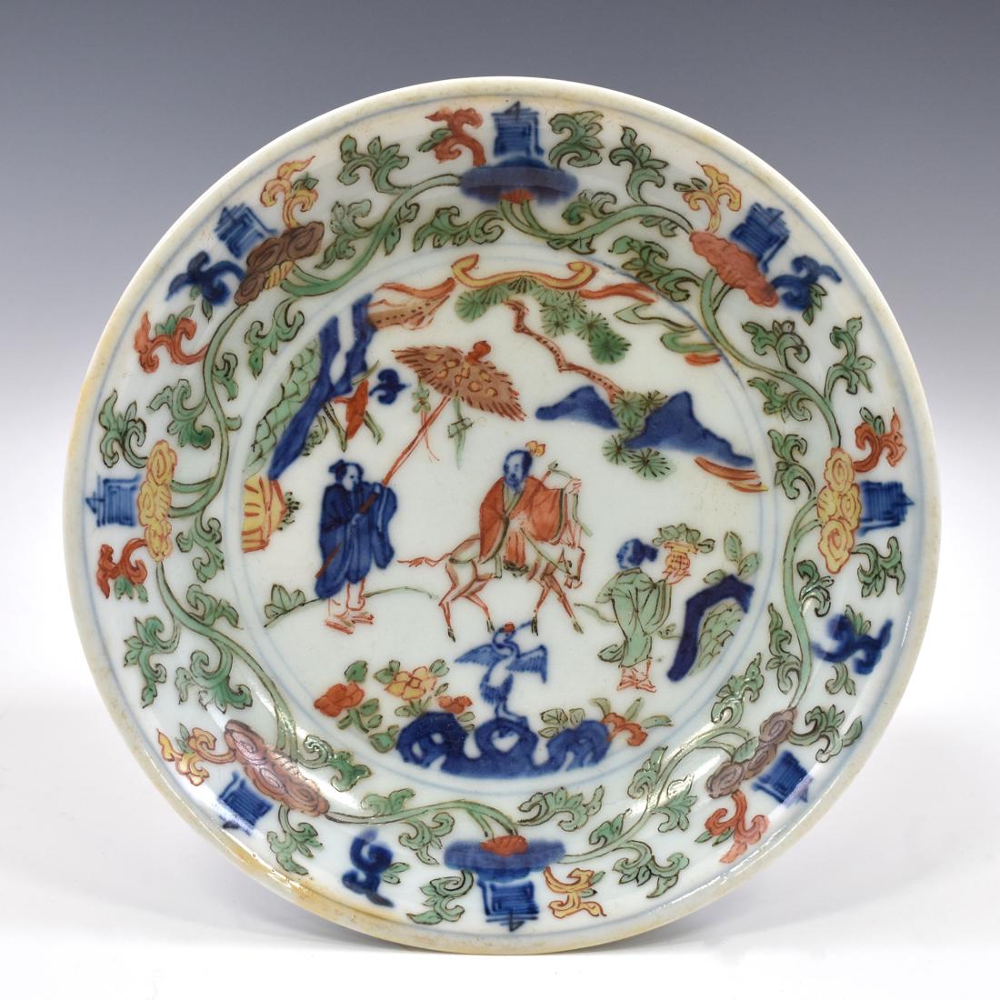 MING WANLI WUCAI FIGURINE PORCELAIN PLATE: Finely preserved Chinese porcelain in a shallow vessel, with rounded cavetto rising to form the raised sides. The plate has a slightly flared rim and rests upon a ring footed base. The focal image dep