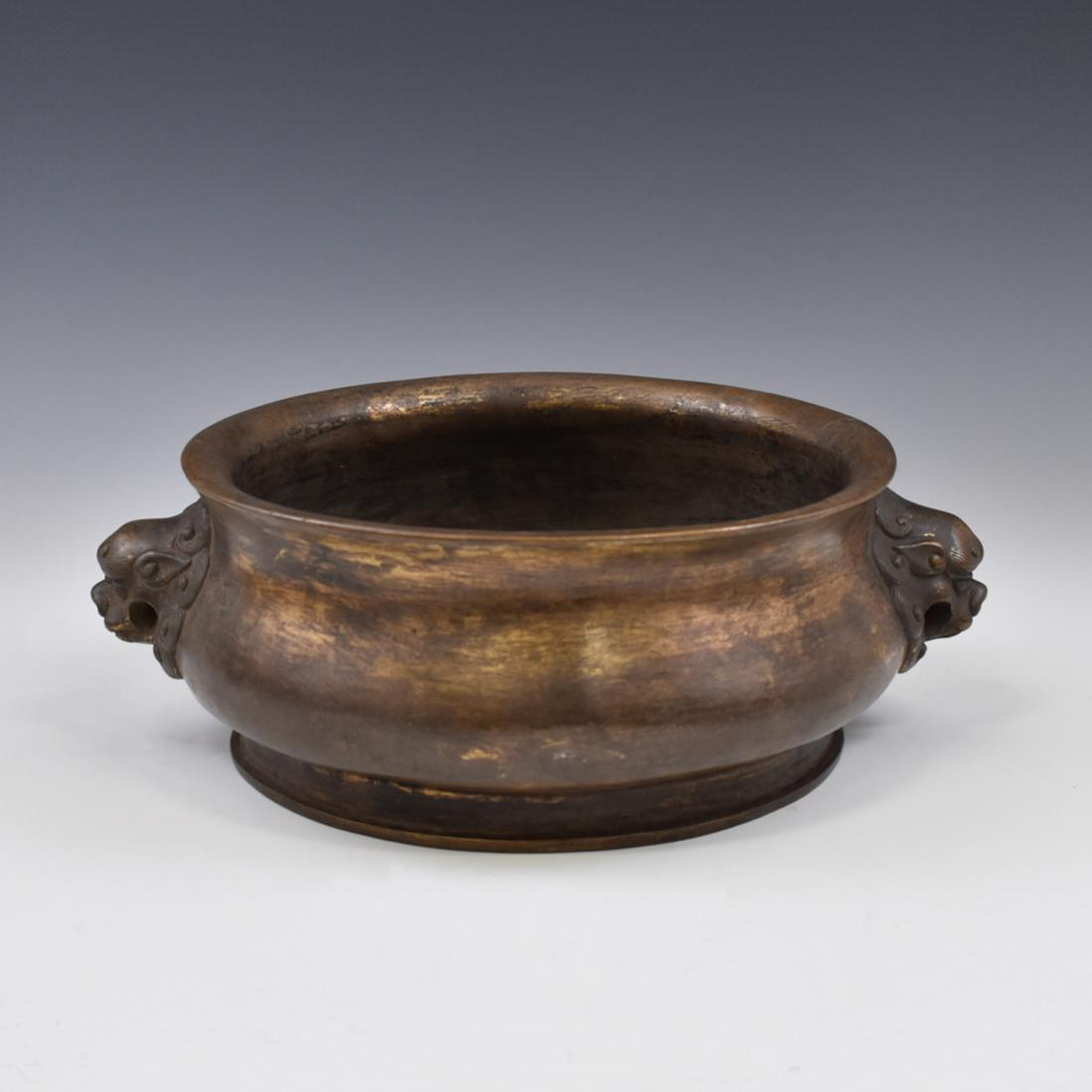 LARGE XUANDE BRONZE CENSER: LArge Chinese Ming bronze censer. Resplendent Xuande censer forged in bronze. The footing protrudes from the bottom of the censer mating to corresponding grooves located on a flat round foot ring on a