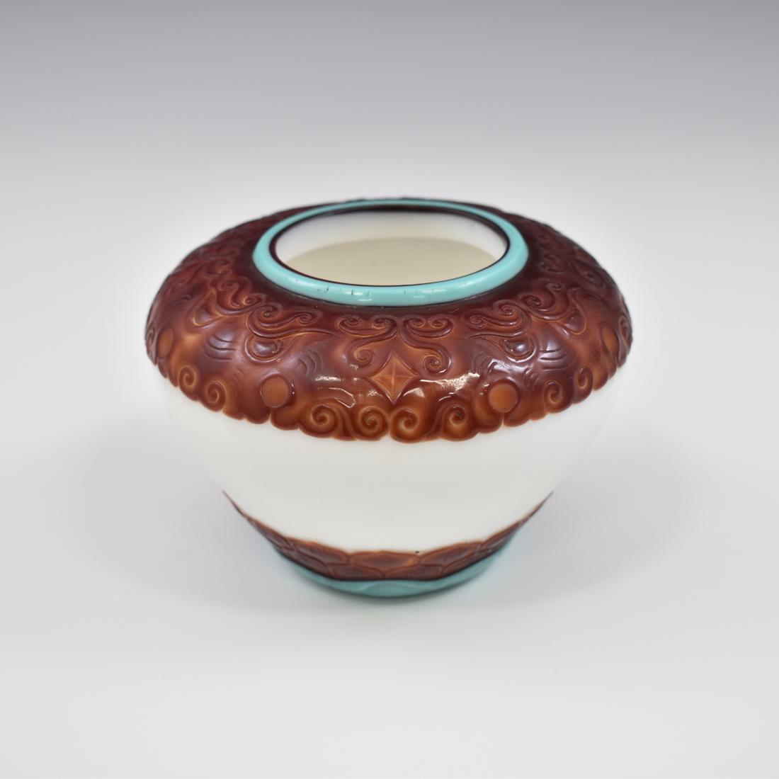THREE COLOR CARVED PEKING GLASS JAR: Chinese red and White Peking Glass Brush Washer Pot. Jar with contracted opening, full shoulder, and oviform belly. This type of jar in the shape of a Buddhist begging bowl. Depicted various mythical 