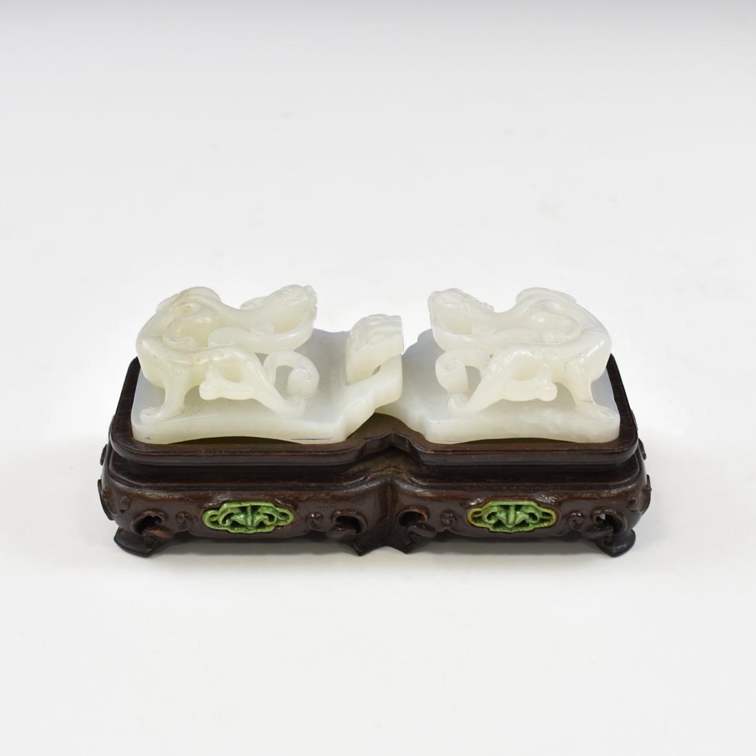 CARVED TIGER MOTIF JADE BELT BUCKLE: The nephrite jade carved in shape of two square body with hinged buckle and loop on each, a striding tigers carved in relief on the top surface. The jade shows pale creme color, with sporadic golden r