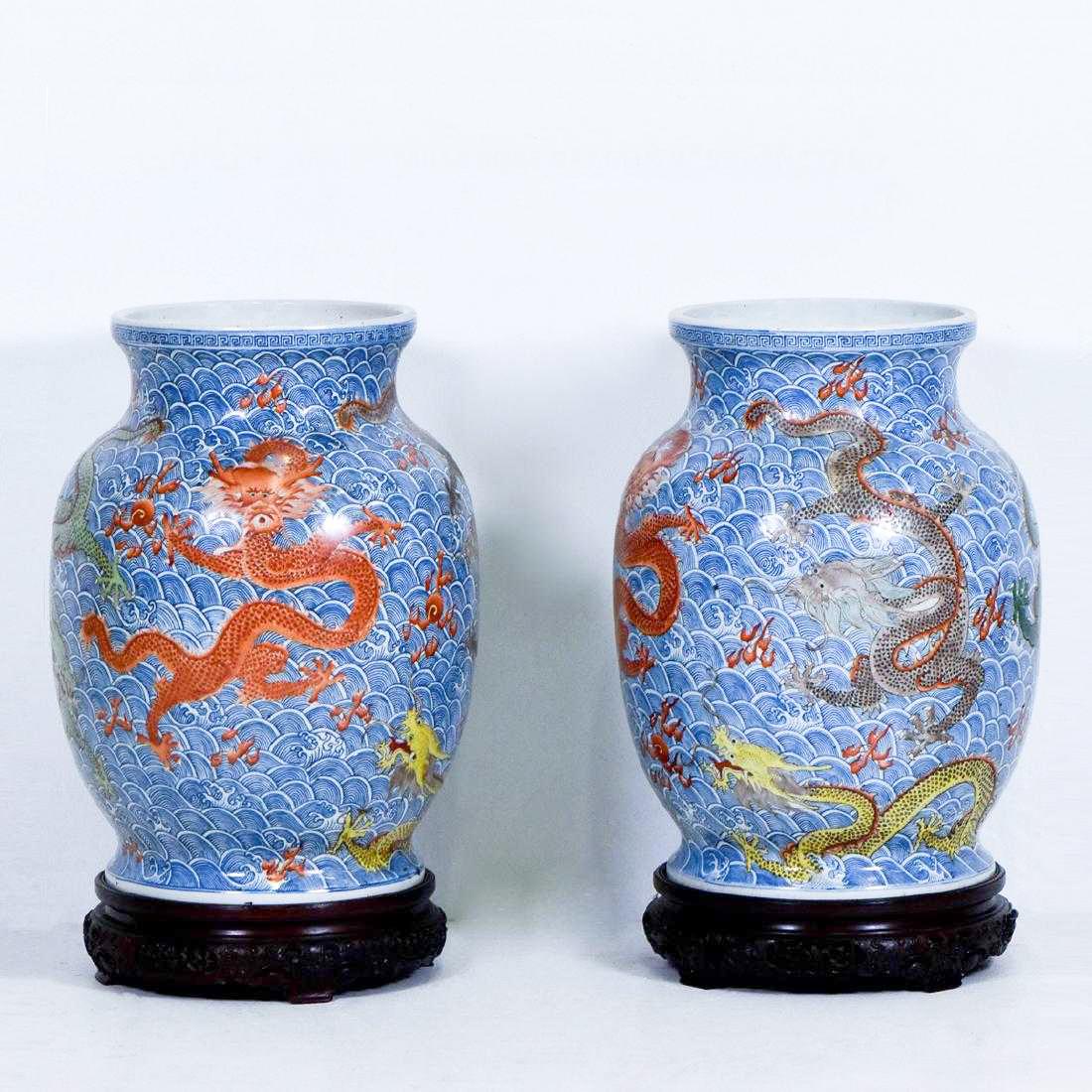 PAIR OF LARGE DRAGONS PORCELAIN VASES ON STAND: Pair of Large Chinese porcelain vases, potted in shape of baluster form, with bulbous tall belly, the round shoulder gently waisted toward the banded rim, raised upon splayed concaved foot base. The e