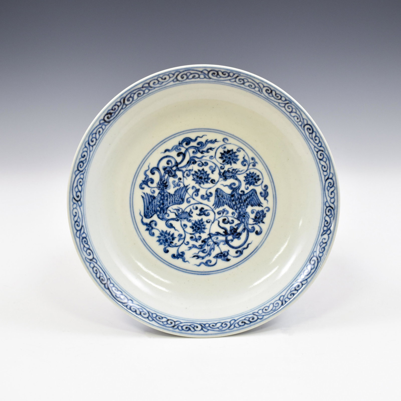 XUANDE BLUE AND WHITE PHOENIX WRAPPED FLORAL PLATE: Dimensions: 1-1/2" H x 7-3/4" Dia. Chinese Ming Dynasty Xuande blue and white Phoenix porcelain plate. Thick potted with a shallow body, of a shallow vessel, broad wide cavetto, with a slightly flared