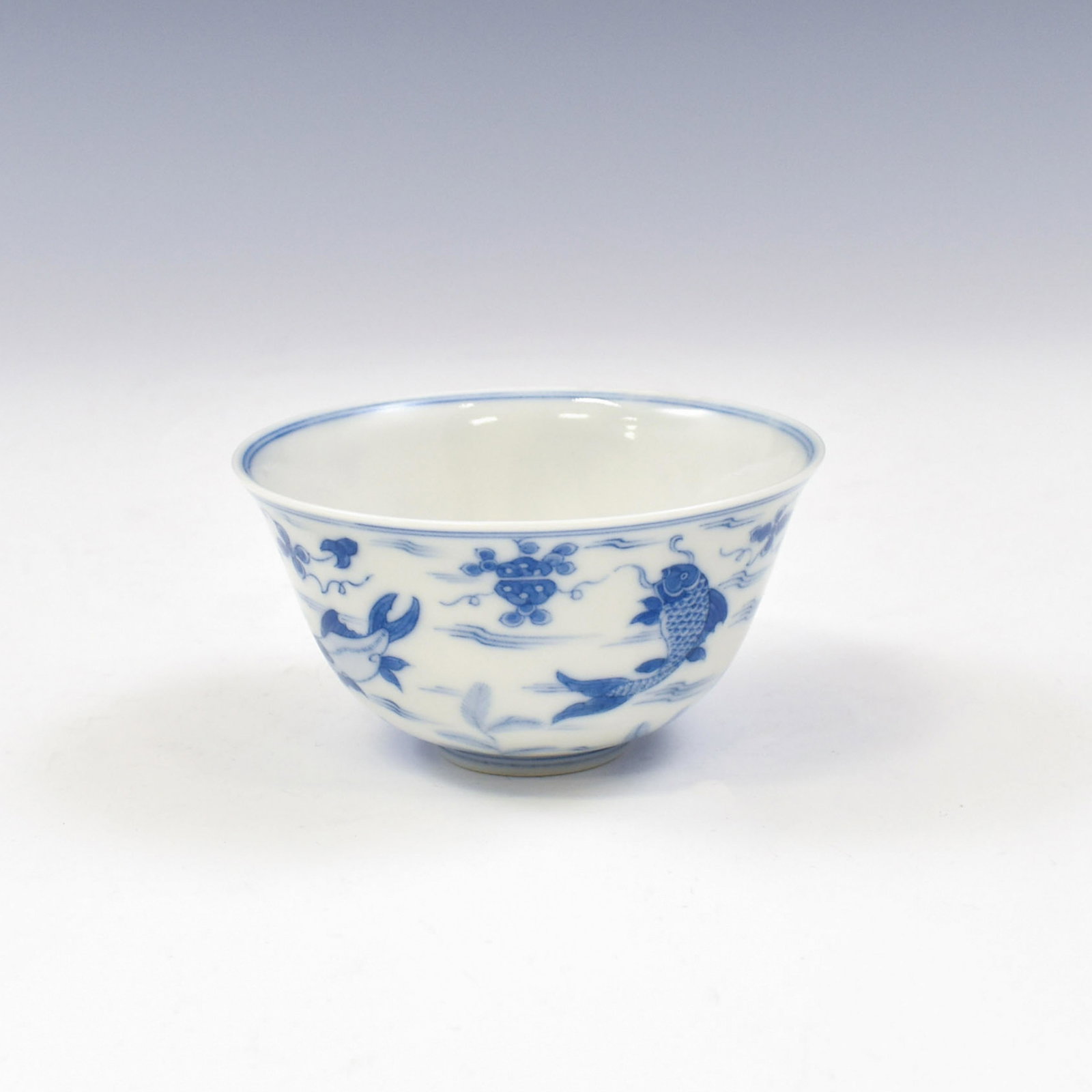 CHENGHUA BLUE & WHITE LEAPING CARP WINE CUP: Chinese Ming Dynasty Chenghua blue & white leaping carp motif porcelain wine cup. Mark on under base, a horizontal six under glazed blue script characters reign mark, enclosed within double fine rings