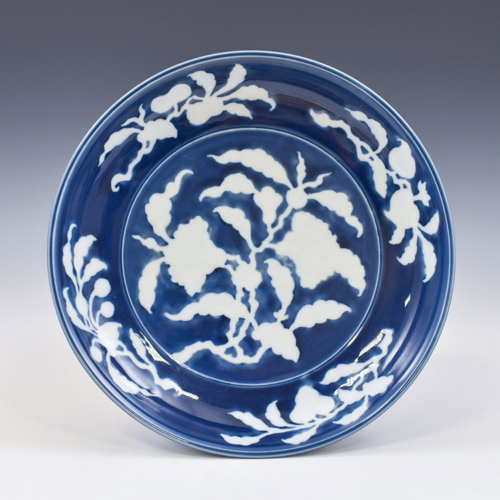 MING REVERSED BLUE FRUIT ABUNDANT BLUE PLATE: Chinese Ming Dynasty Period, reversed blue fruit abundant motif porcelain plate. The porcelain potted in shallow vessel form, thick and large, thick, with broad wide central interior, rounded cavetto 