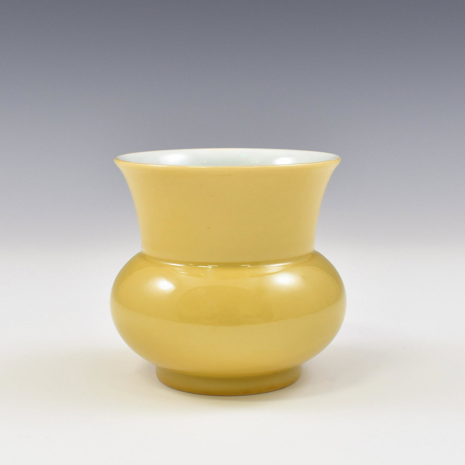 QIANLONG FAMILLE JAUNE MONOCHROME ZADOU BEAKER VASE: Chinese Qing Dynasty Period, Qianlong famille jaune monochrome porcelain zadou beaker vase. The vase potted in a Chinese porcelain traditional zadou beaker shape, having baluster shaped body, short an