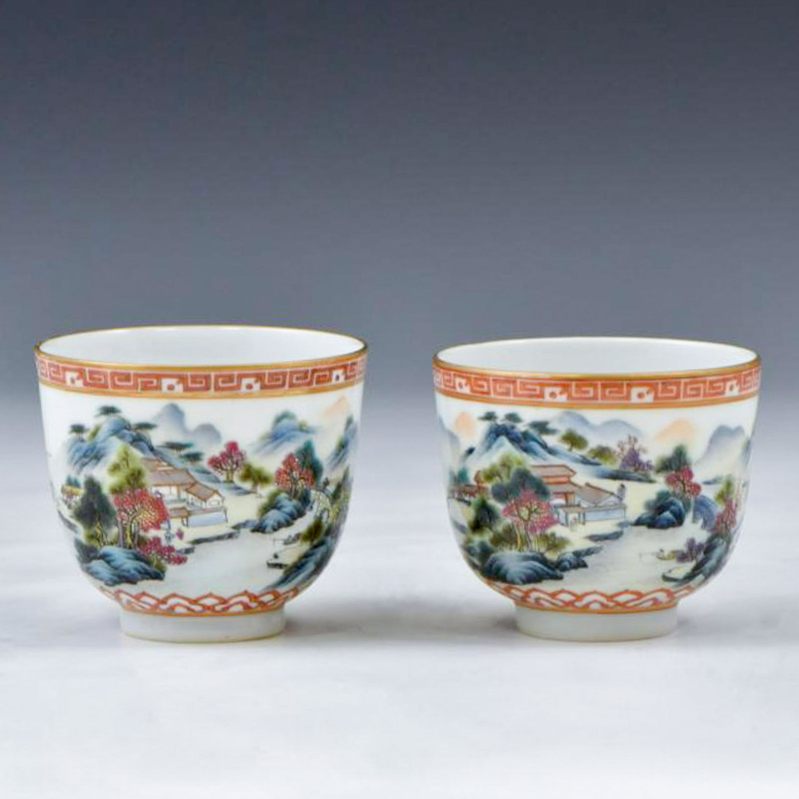 PAIR OF FAMILLE ROSE LANDSCAPE BOWLS: The Chinese porcelain bowls is finely potted with round cavetto gently elevating the steep vertical sides towards flat opening, and raised upon a concaved base. The exterior delicately hand painted in