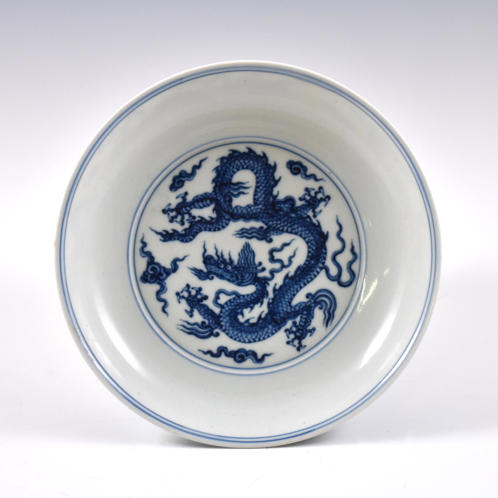 XUANDE BLUE & WHITE DRAGON PLATE: Dimensions: 1-3/4" H x 8-3/8" Dia. Chinese Ming Dynasty Period, XuanDe plate. The porcelain potted in shallow vessel form, thick and large, with broad wide central interior, rounded cavetto gently tap