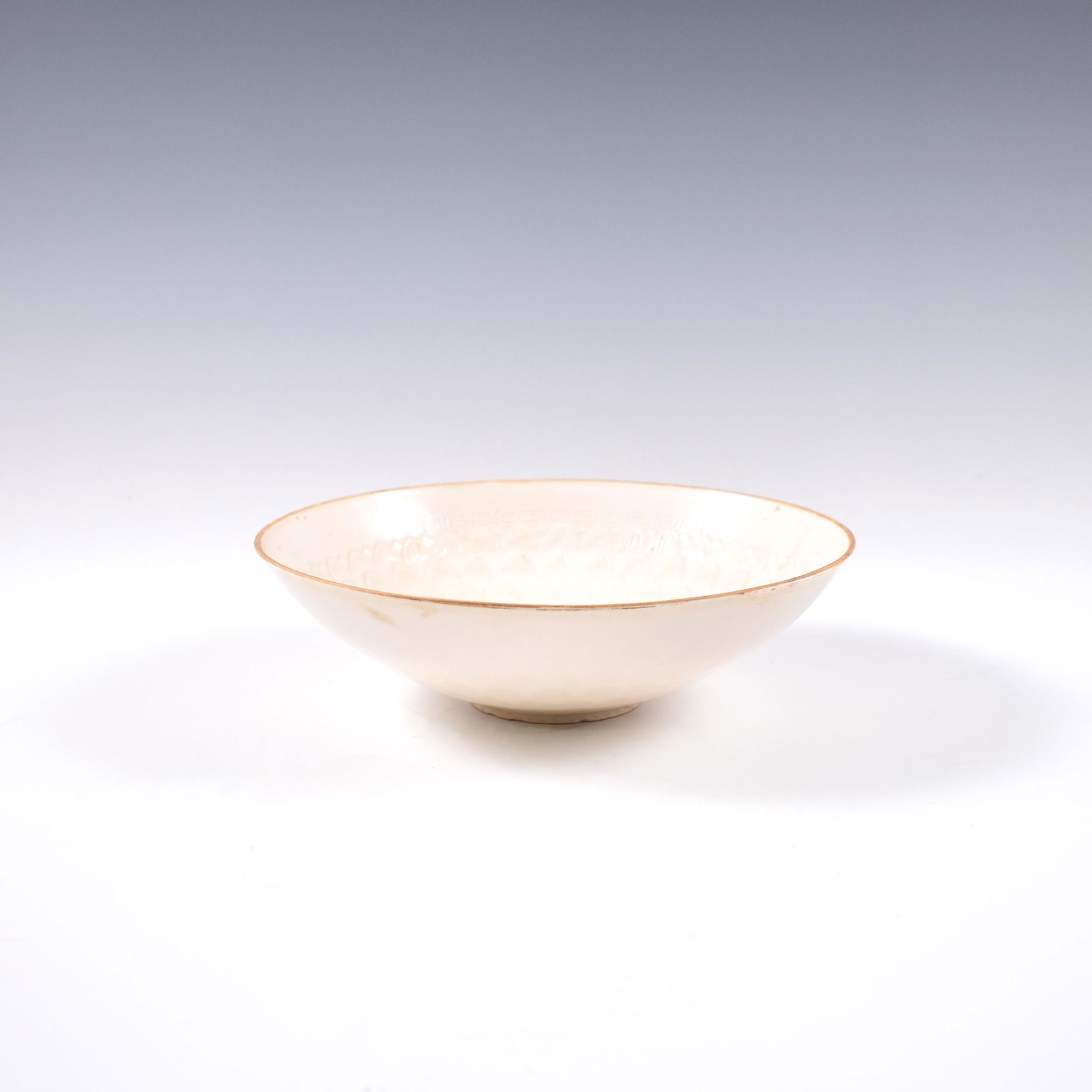 CHINESE DING WARE BOWL: Dimensions: 2-7/8" H x 8-1/4" Dia. Chinese Ding ware, potted in a shallow vessel, with wide broad cavetto rising a steep sides, raised on a narrow footed base. The rim is bound in brown and incised de