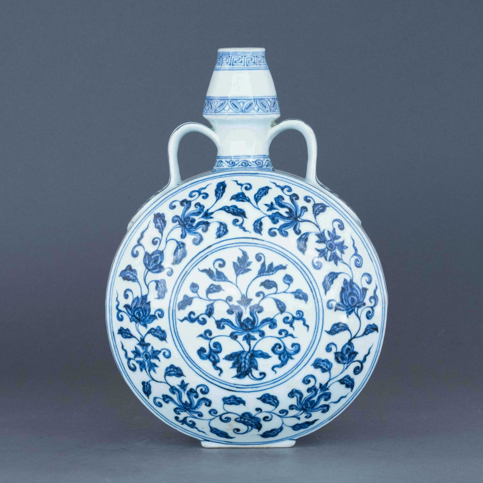 MING YONGLE BLUE & WHITE WRAPPED FLORAL MOON VASE: Dimensions: 12.125in H x 8.25in W x 5.25in D Chinese Ming Dynasty Period Yongle blue & white wrapped floral moon vase. The porcelain with tall ovoid body, thick, with bulbous lower region, sweeping up