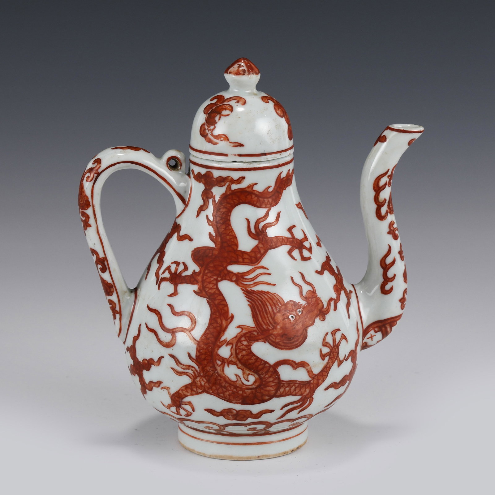 IRON RED DRAGON MOTIF PORCELAIN LIDDED EWER: Dimensions (cm): Height: 18 Length: 14 Width: 11 Chinese Ming Dynasty Period Iron Red Dragon Motif Ewer. Potted in wine spout, globe-shaped abdomen, deep and thick, round straight upward to form openi