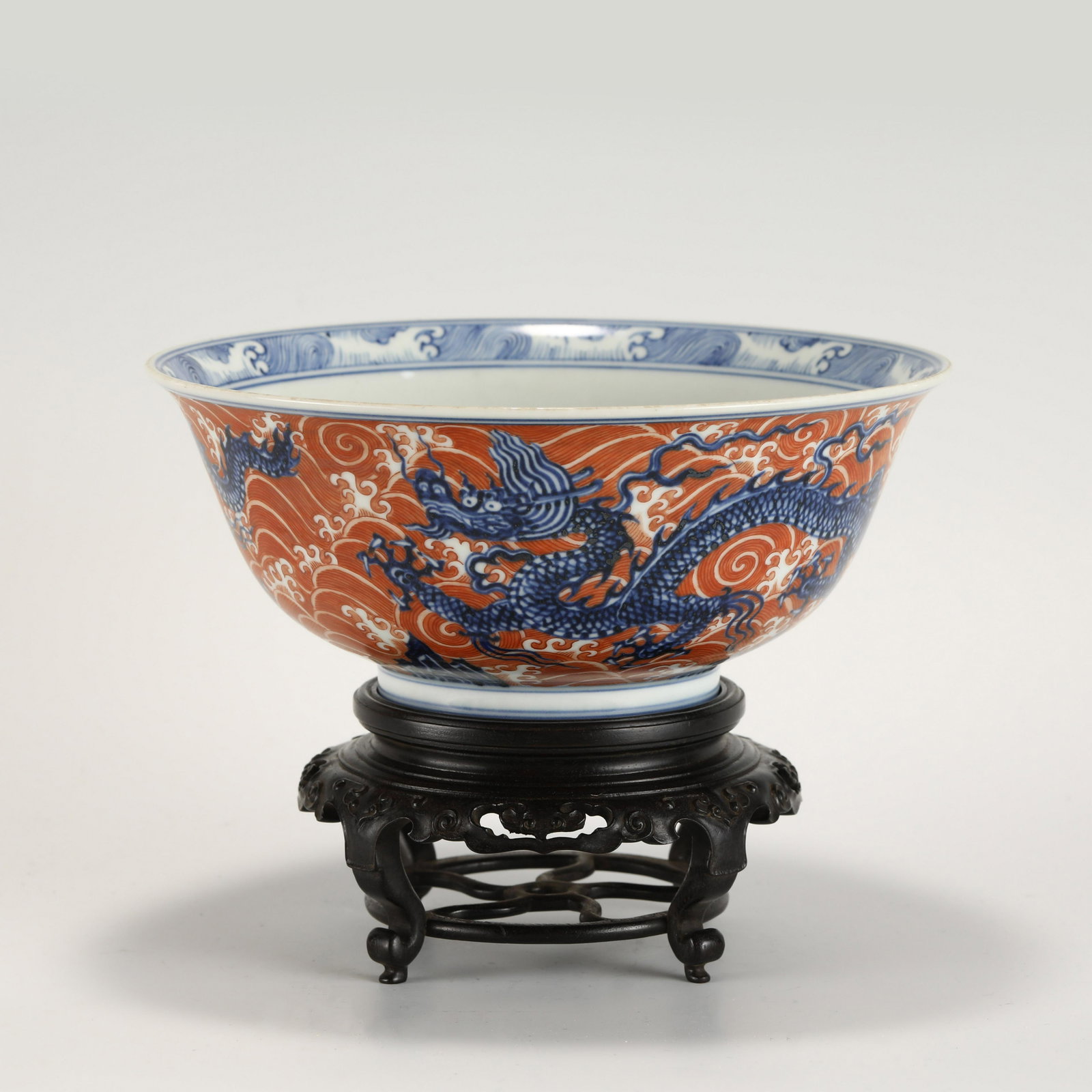 MING XUANDE BLUE AND WHITE ALUM RED BOWL: PROVENANCE: From Bluffton, SC Private Collector. Dimensions: Heigth: 9.5 cm, Diameter: 22.5 cm Chinese Ming Dynasty XuanDe Blue and White Alum Red Dragon Porcelain Bowl On Carved Hardwood Stand. The p